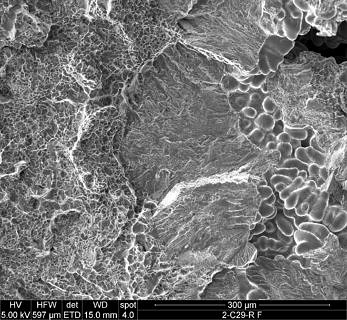 Crack-causing shrinkage hole in the fracture surface of a permanent mold casted part